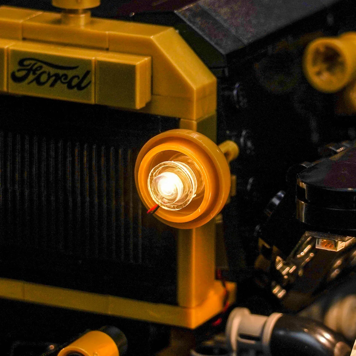 Nahaufnahme eines gelben Lego-Autos mit leuchtendem Scheinwerfer und Ford-Logo