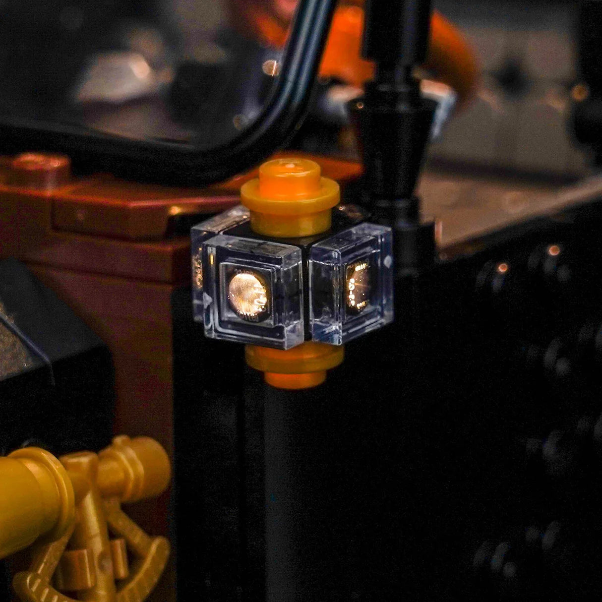 Nahaufnahme eines leuchtenden Lego-Steins mit drei sichtbaren Seiten und gelben Verbindungsstücken