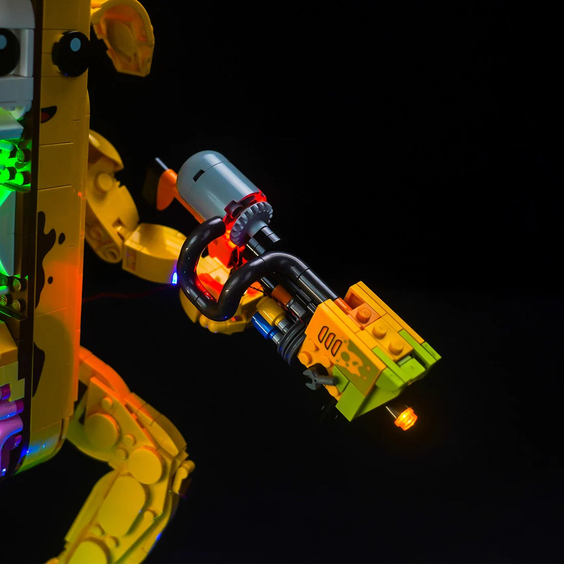 Nahaufnahme einer leuchtenden gelben und grünen LEGO-Waffe mit roten und blauen Lichtern