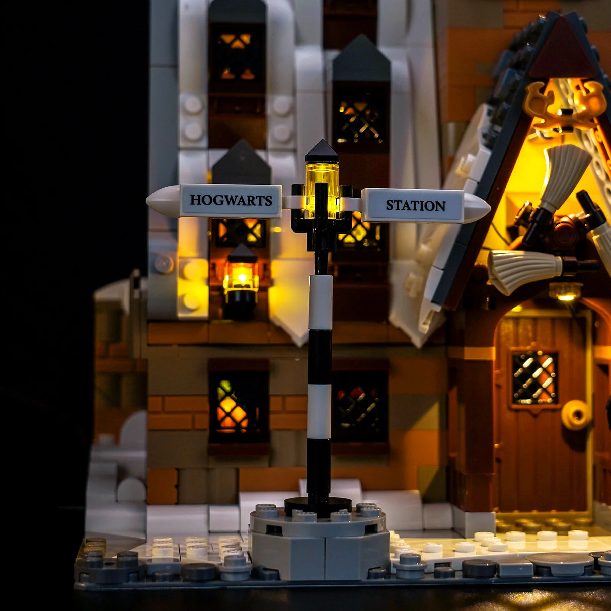 Ein beleuchtetes LEGO Hogwarts Bahnhofsmodell mit Wegweiser