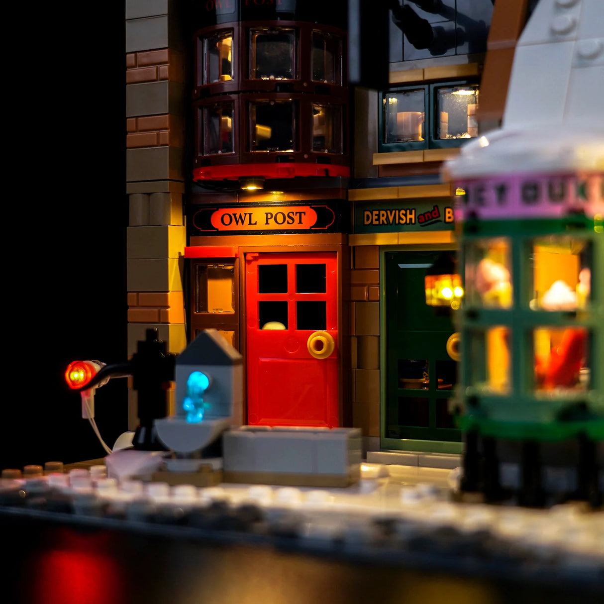 Nahaufnahme eines beleuchteten Lego-Gebäudes mit einem roten Tor und einem Schild mit der Aufschrift Owl Post