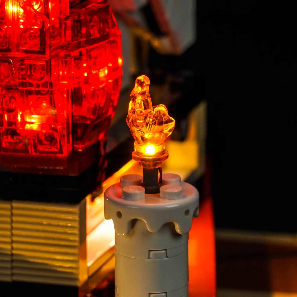 Leuchtende orangefarbene Flamme auf einem grauen Legostein mit rotem Licht im Hintergrund