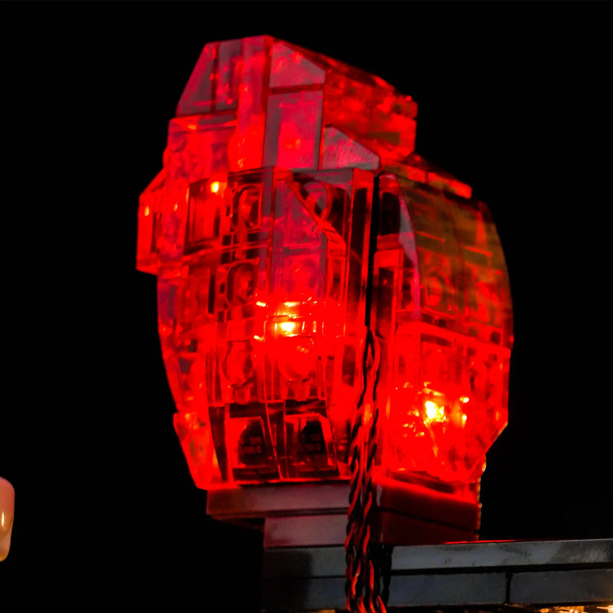 Rotes, leuchtendes, transparentes Objekt mit Kabeln auf schwarzem Hintergrund