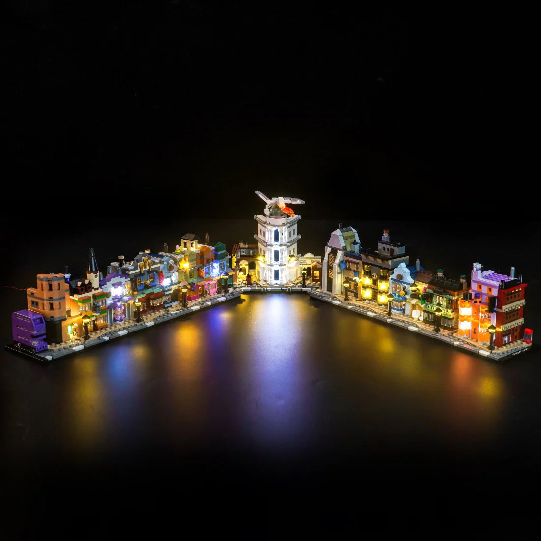 Beleuchtetes LEGO-Modell einer Stadt mit Leuchtturm und Gebäuden bei Nacht