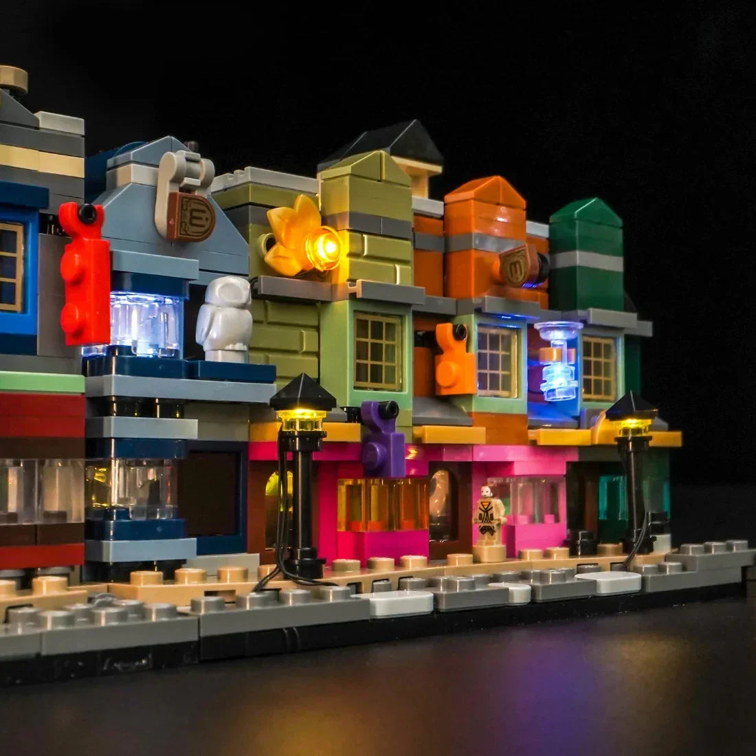 Beleuchtetes LEGO-Gebäude mit bunten Lichtern und Straßenlaternen in der Nacht
