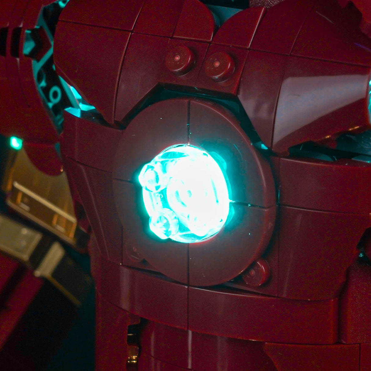 Nahaufnahme des leuchtenden blauen Arc-Reaktors auf der Brust eines roten Iron Man Lego-Modells