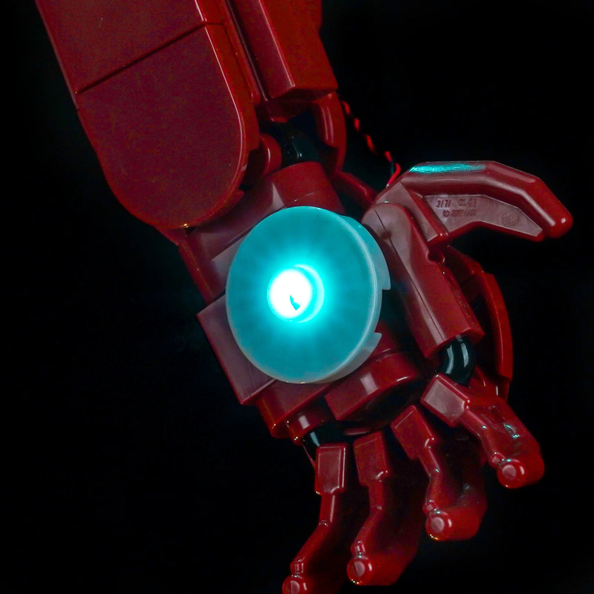 Roter Lego Iron Man Arm mit leuchtendem blauen Repulsorstrahl in der Handfläche