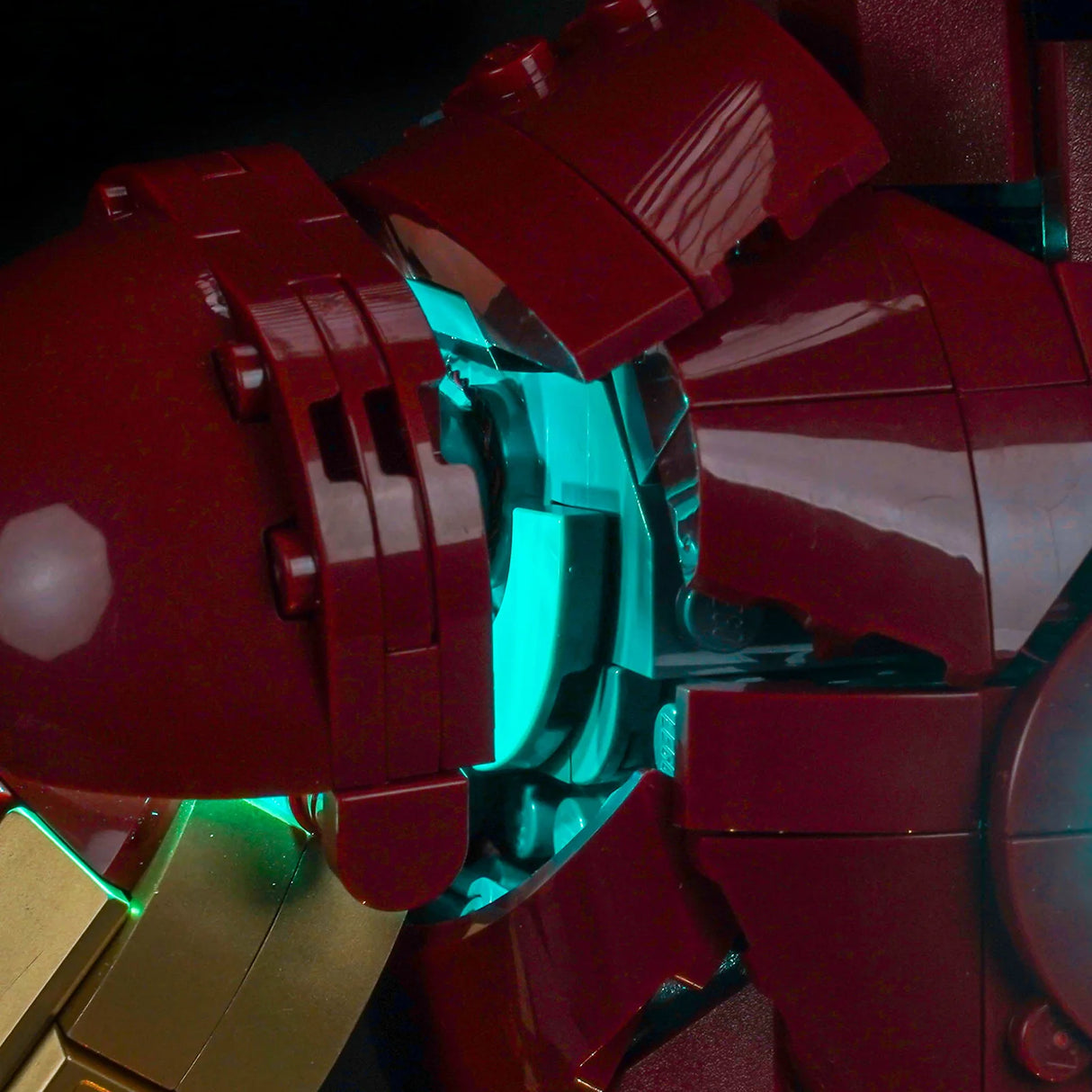 Nahaufnahme eines roten und goldenen Lego Iron Man Anzugs mit leuchtend blauem Licht aus der Brust