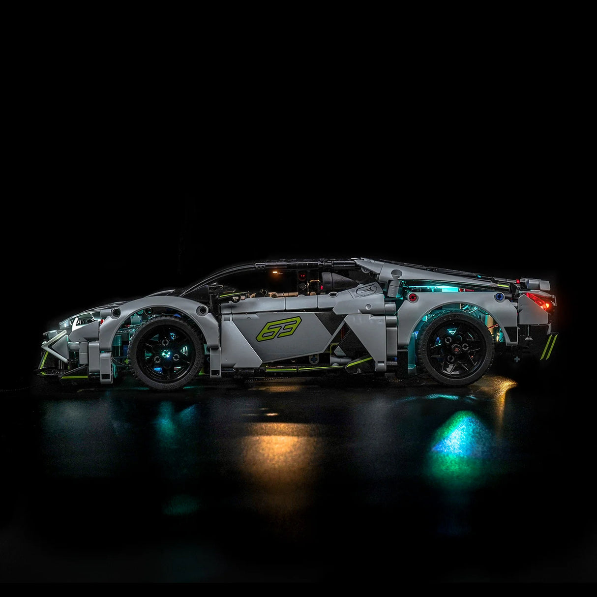Graues Spielzeugauto mit leuchtenden Rädern und grünen Akzenten auf schwarzem Hintergrund