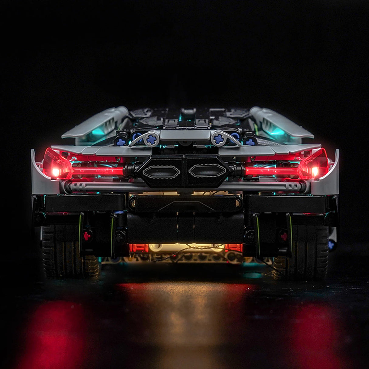 Rückansicht eines grauen Spielzeugautos mit leuchtenden roten Rücklichtern und blauen Akzenten
