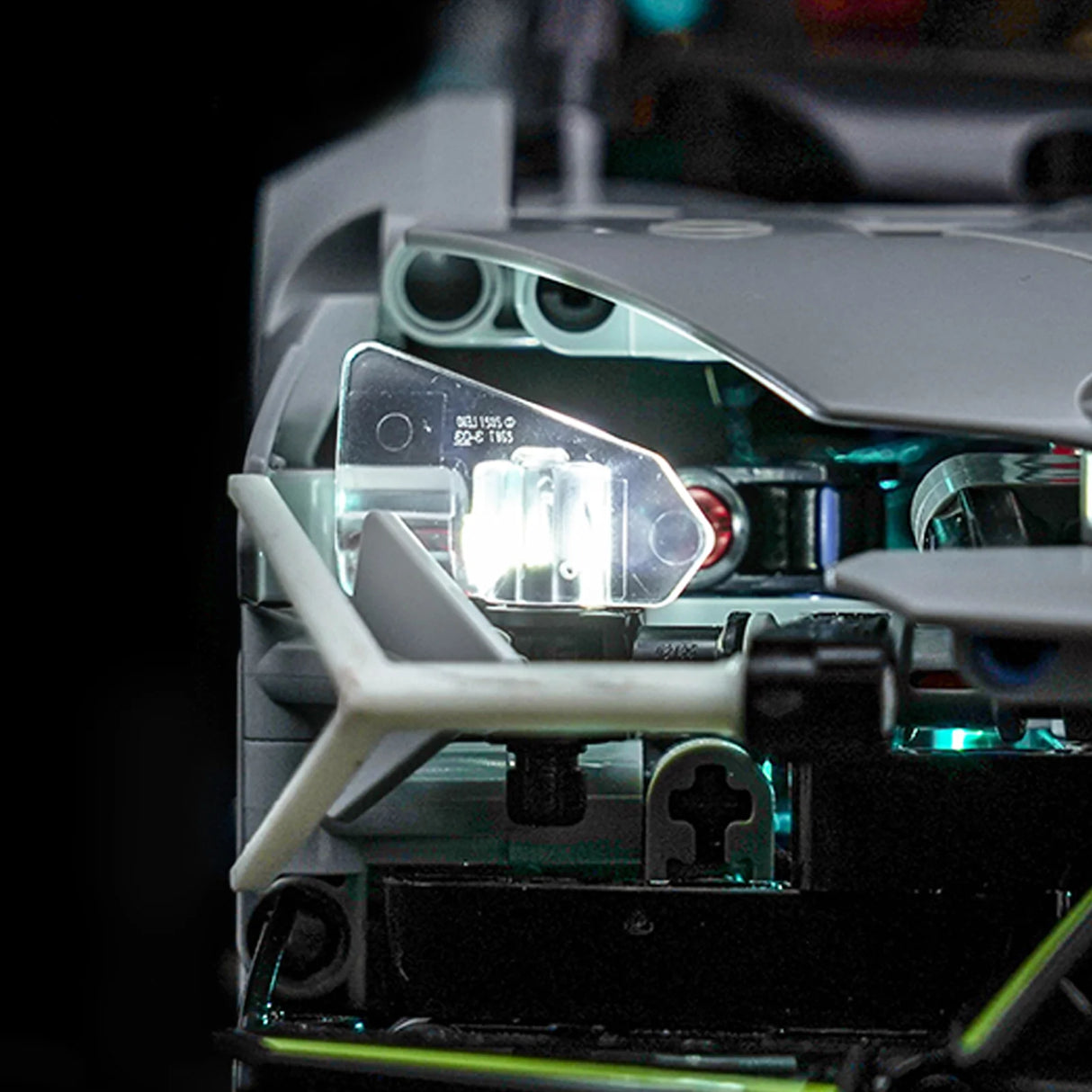 Nahaufnahme eines beleuchteten Scheinwerfers eines grauen Lego-Autos