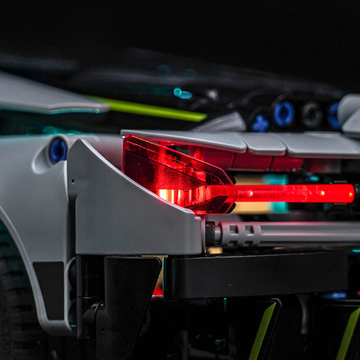 Rücklicht eines grauen Spielzeugautos mit leuchtend roten Lichtern