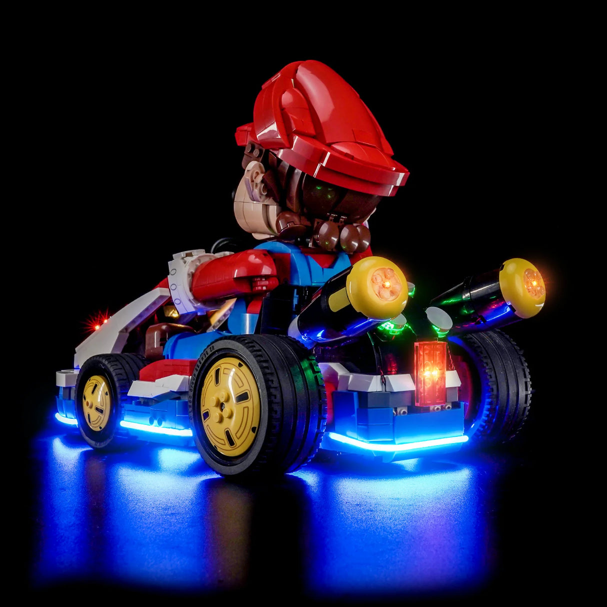 LEGO Mario Kart mit leuchtenden blauen Unterbodenlichtern und gelben Scheinwerfern auf schwarzem Hintergrund
