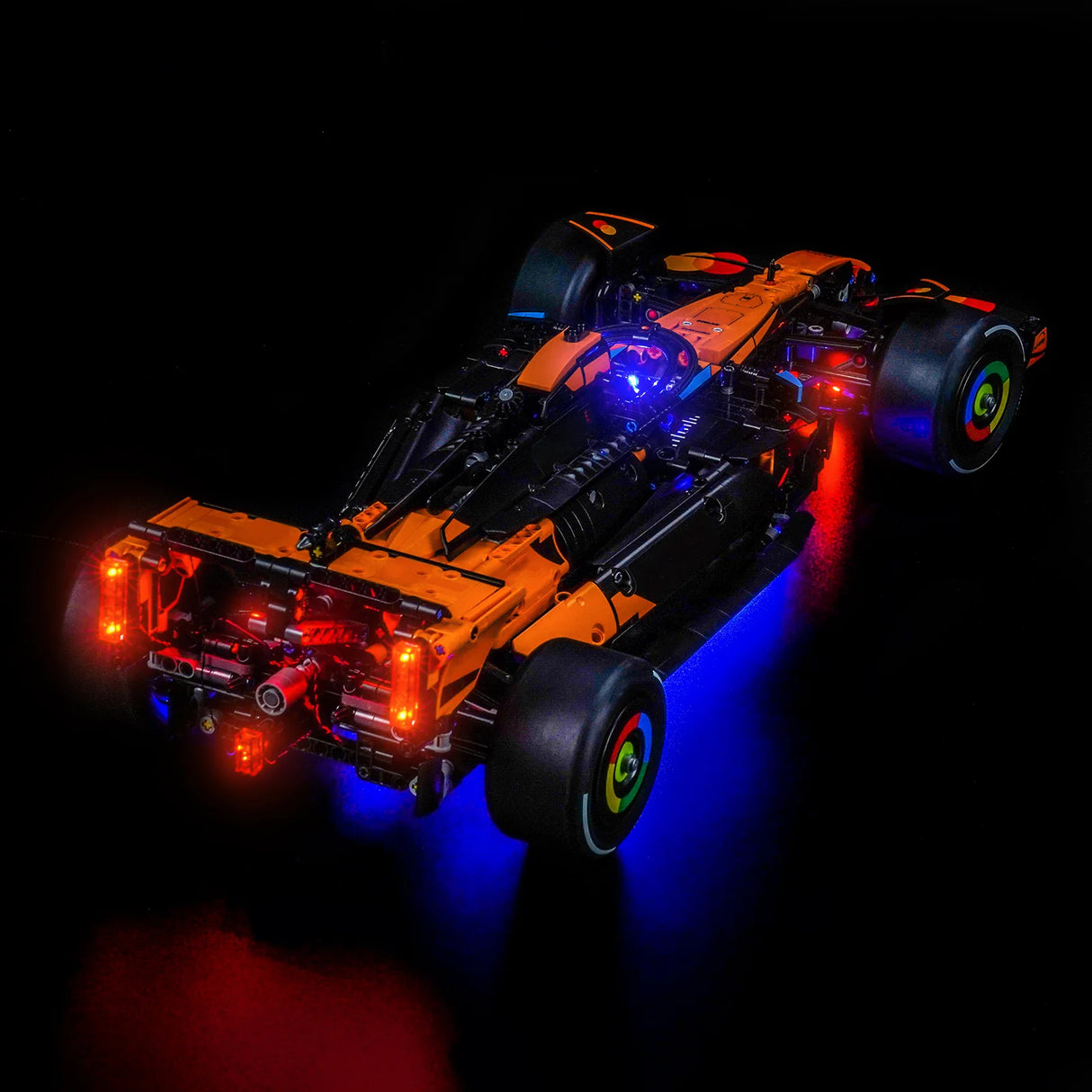 Orangefarbener und schwarzer McLaren Formel-1-Rennwagen mit leuchtenden roten und blauen Lichtern
