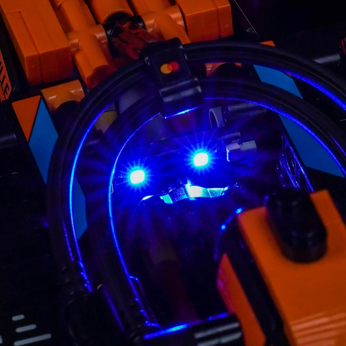 Nahaufnahme eines orangefarbenen Spielzeugautos mit leuchtend blauen Lichtern