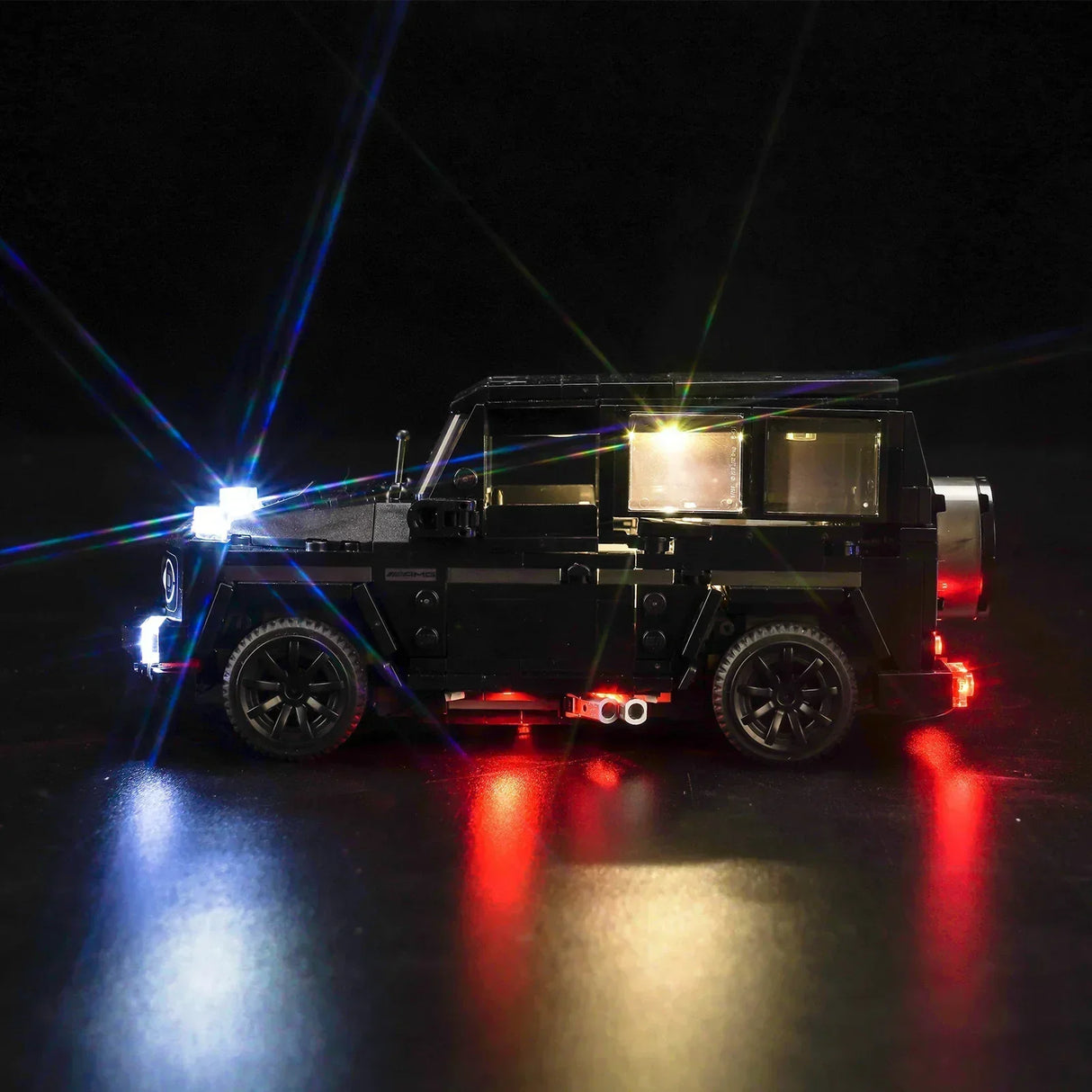 Schwarzes Modellauto mit eingeschalteter LED Beleuchtung vor dunklem Hintergrund