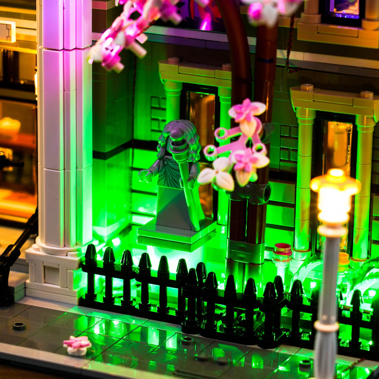 Lego-Modell eines Gebäudes mit grüner Beleuchtung und einer Statue im Vordergrund