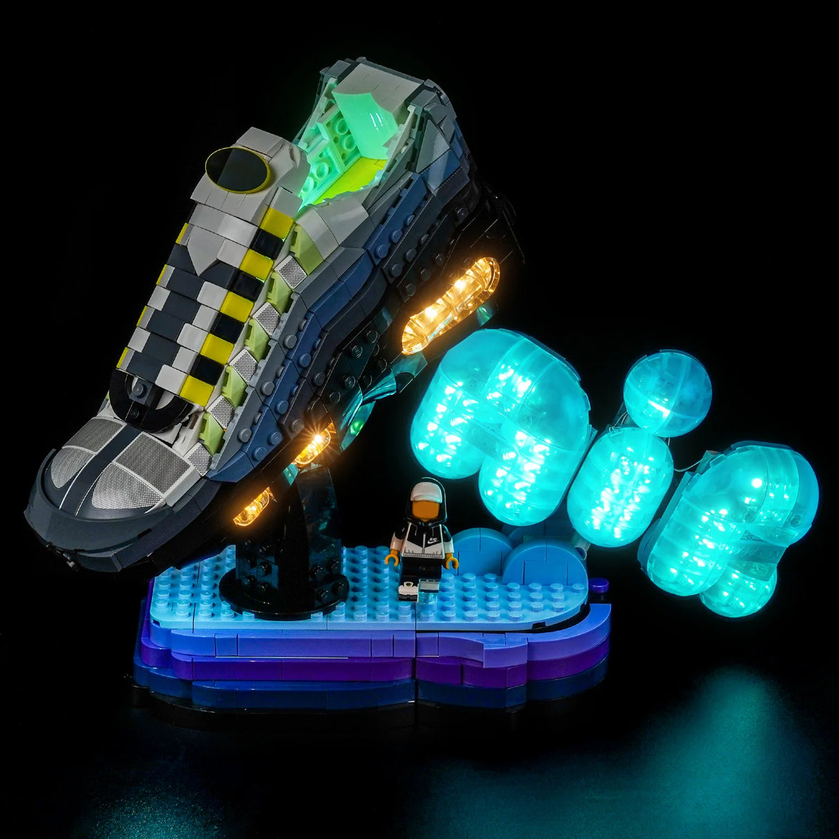 Ein leuchtender Lego-Sneaker mit gelben und grünen Akzenten, umgeben von blauen Lichtelementen auf schwarzem Hintergrund