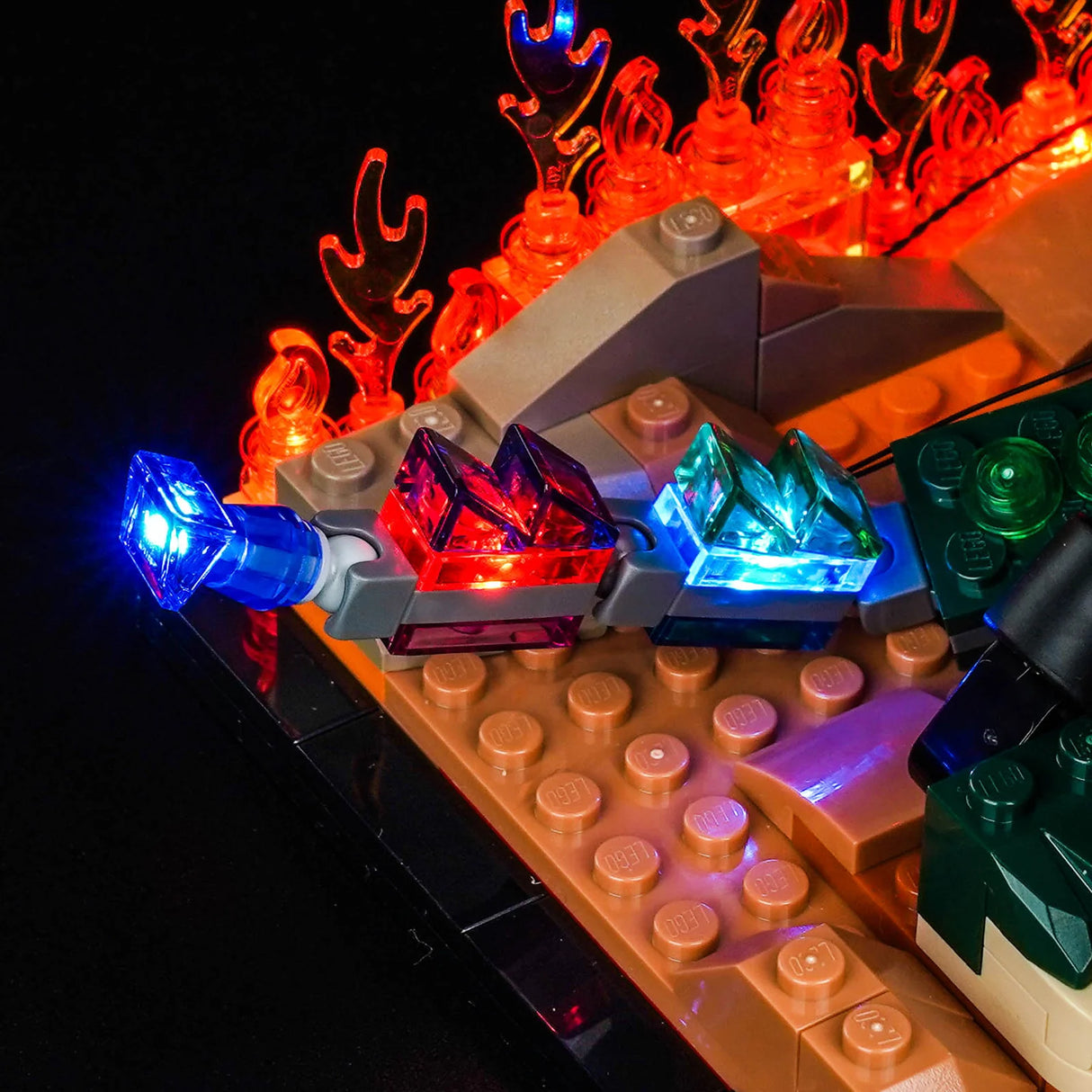 Nahaufnahme von leuchtenden roten und blauen Lego-Kristallen mit orangefarbenen Flammen im Hintergrund