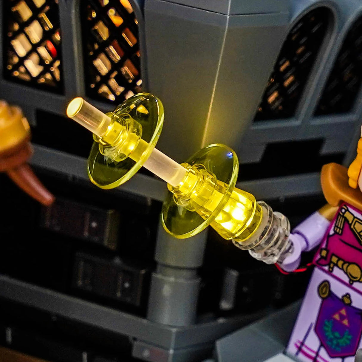 Nahaufnahme eines leuchtenden gelben Lego-Lichtschwertes, das von einer Lego-Minifigur gehalten wird