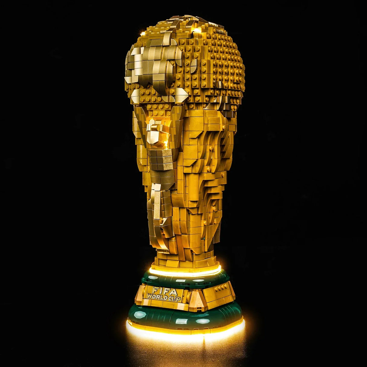 FIFA World Cup Pokal aus goldenen Legosteinen auf grünem Sockel mit leuchtendem Rand