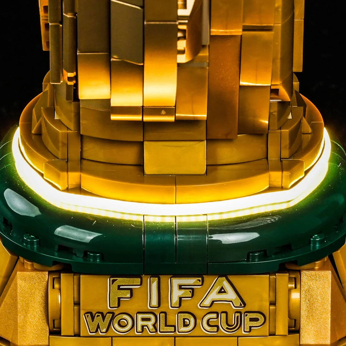 Nahaufnahme des LEGO FIFA World Cup Pokals mit goldener Basis und grüner Umrandung