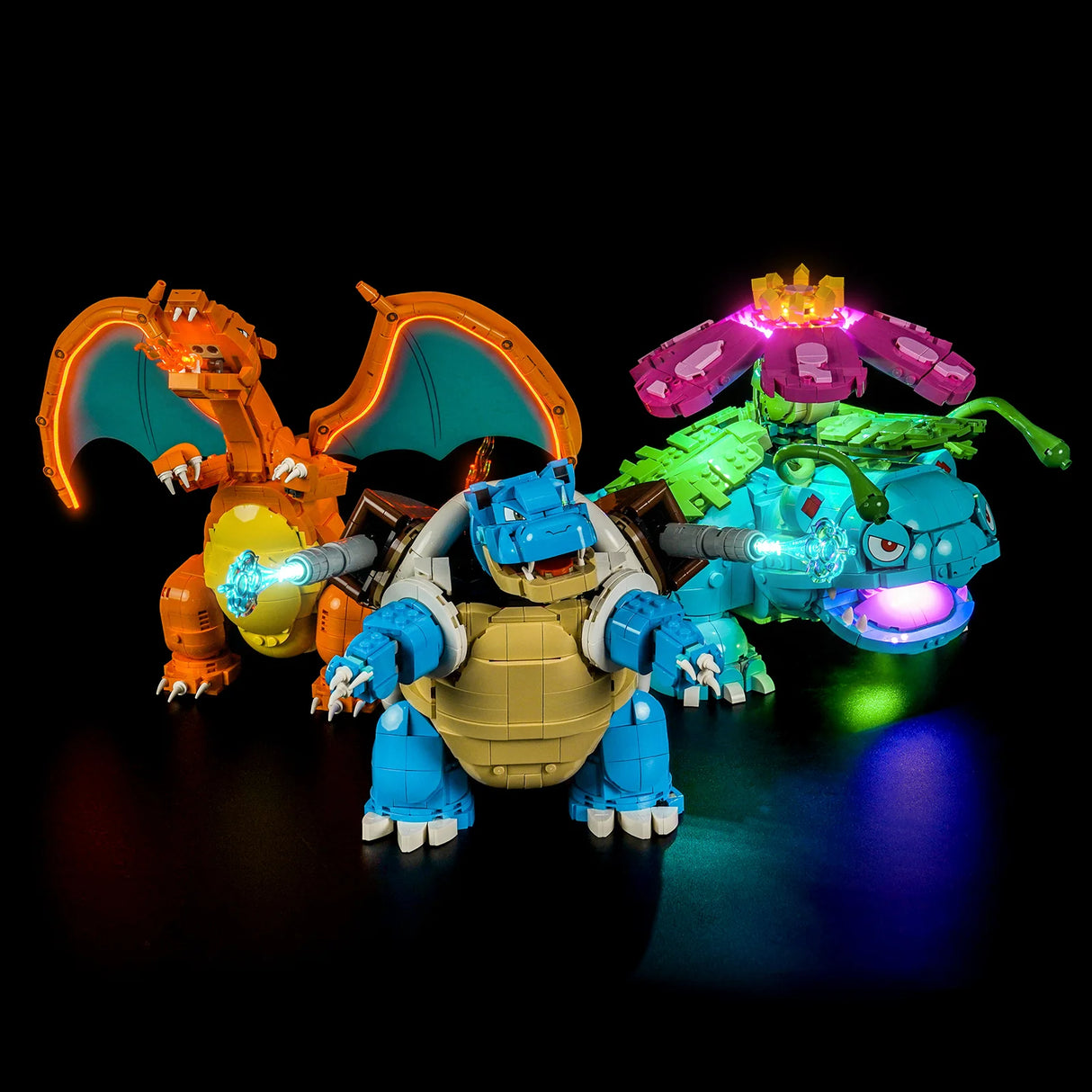 Drei leuchtende Pokémon-Figuren: Charizard, Blastoise und Venusaur, auf schwarzem Hintergrund