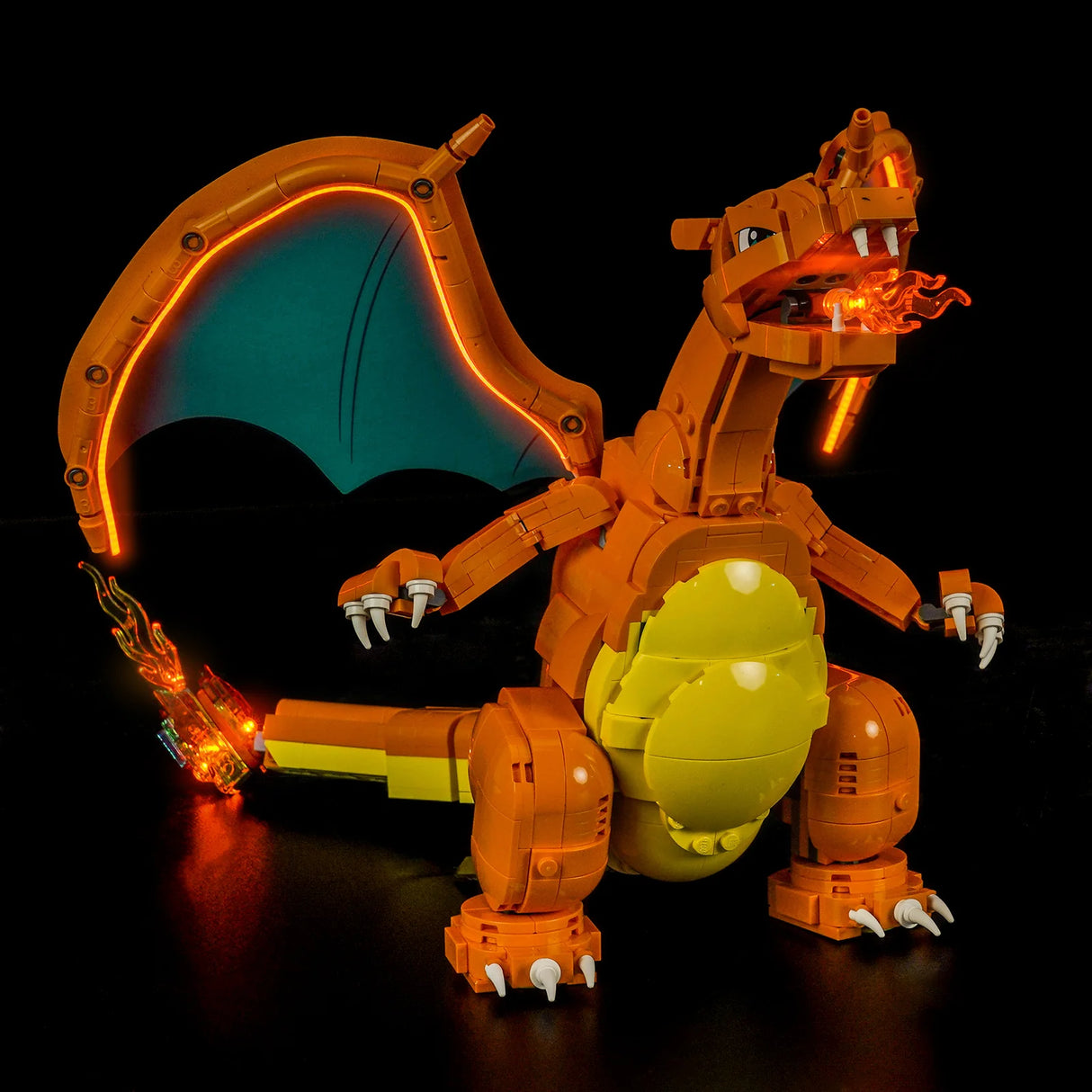 Leuchtendes LEGO Charizard Modell mit orangefarbenen und gelben Details, blauen Flügeln und Flammen aus Mund und Schwanz