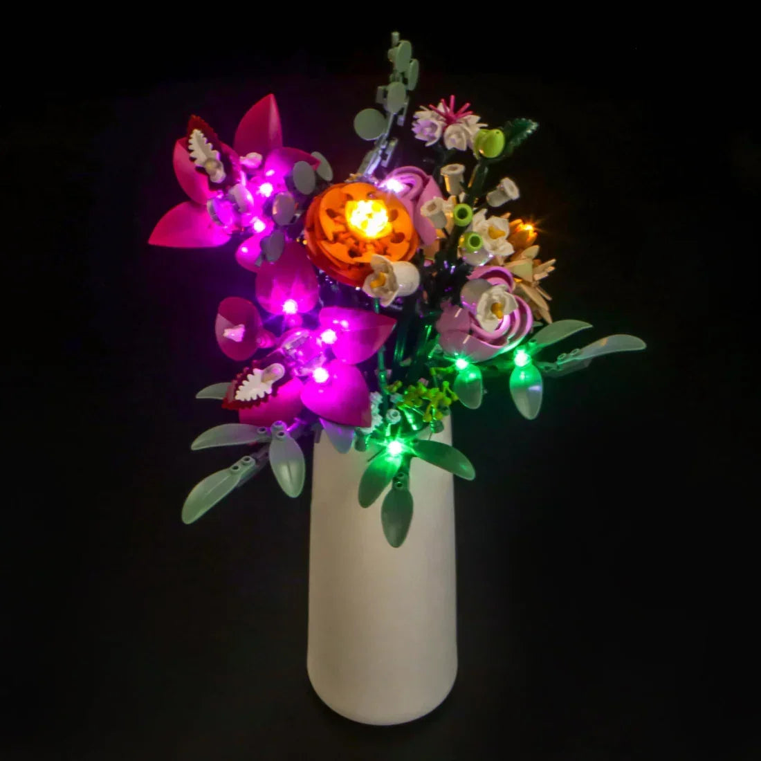Ein Blumenstrauß aus Legosteinen in einer weißen Vase mit leuchtenden Lichtern