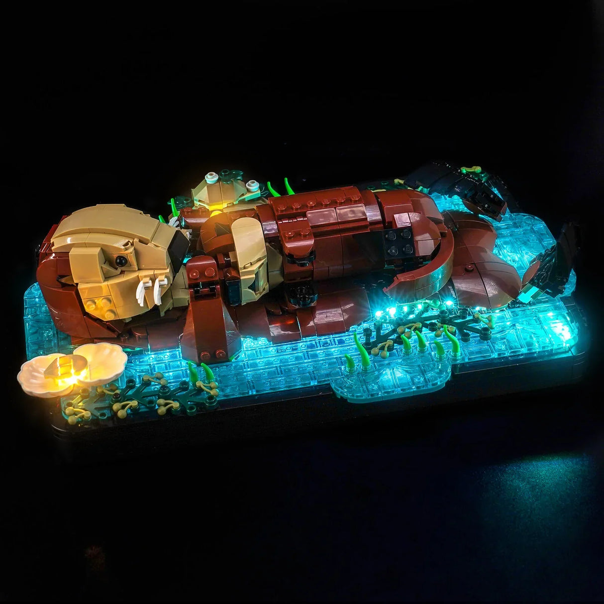 Ein Lego-Modell eines schlafenden Otters auf einem leuchtenden blauen Sockel mit Pilzen und Pflanzen