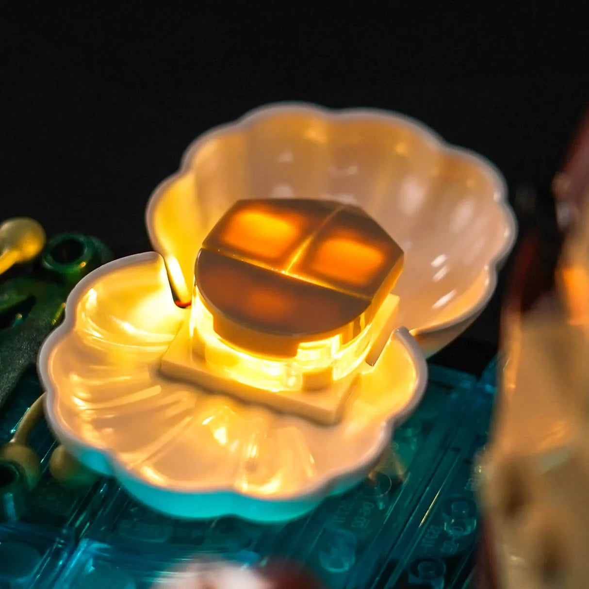 Nahaufnahme einer leuchtenden gelben Lego-Blume auf einer blauen Lego-Platte
