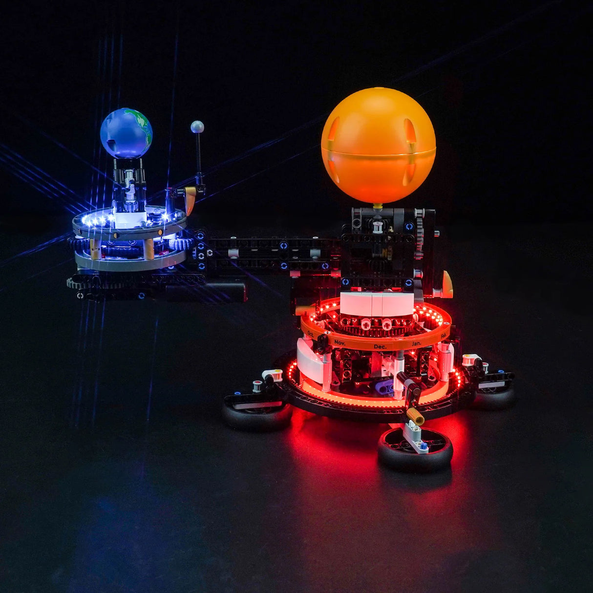 Beleuchtetes Modell eines Planetensystems mit Sonne Erde und Mond auf schwarzem Hintergrund