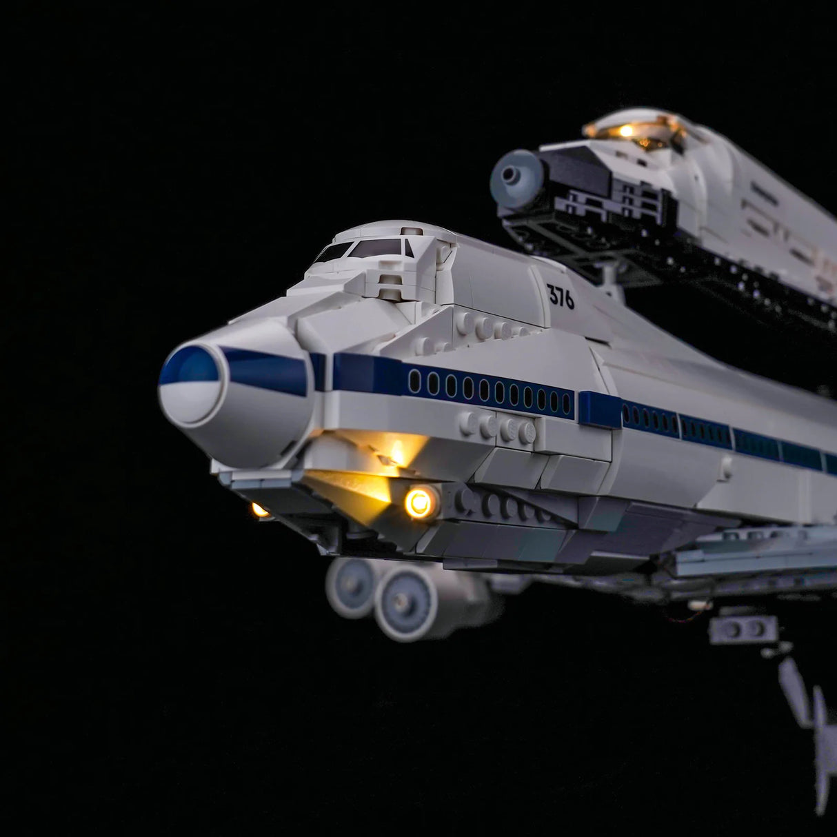 Lego-Modell eines weißen Flugzeugs mit blauen Streifen und einem Raumschiff auf dem Rücken