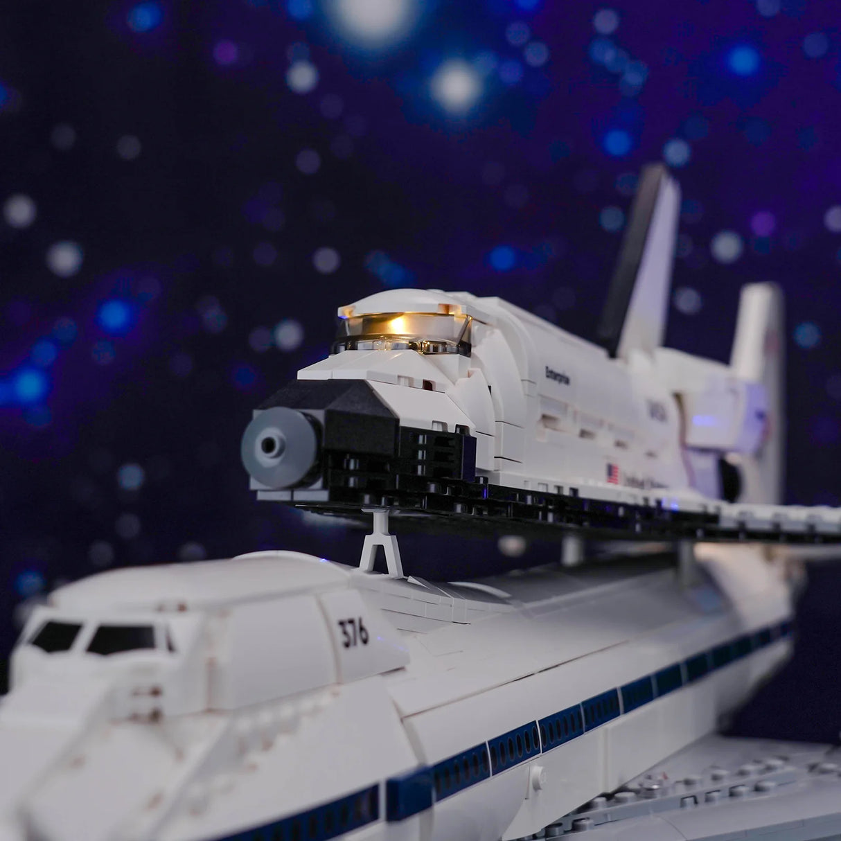 Ein Lego-Modell des Space Shuttles Enterprise auf einem Trägerflugzeug vor einem Sternenhimmel