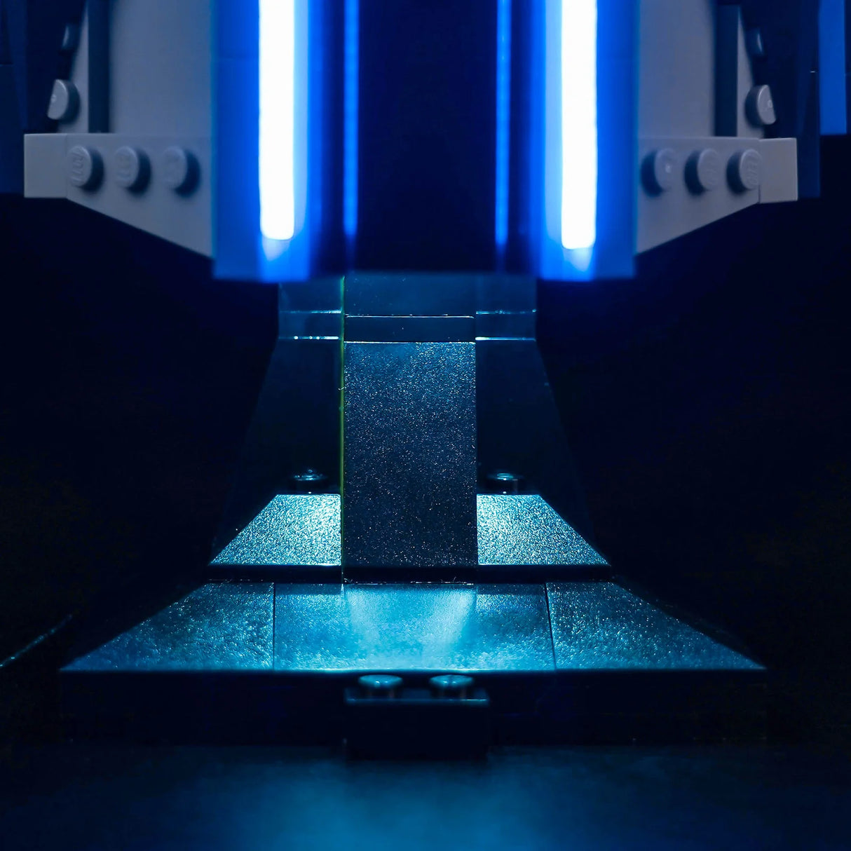Nahaufnahme eines LEGO-Modells mit zwei vertikalen blauen Lichtstreifen und einer dunklen, strukturierten Basis