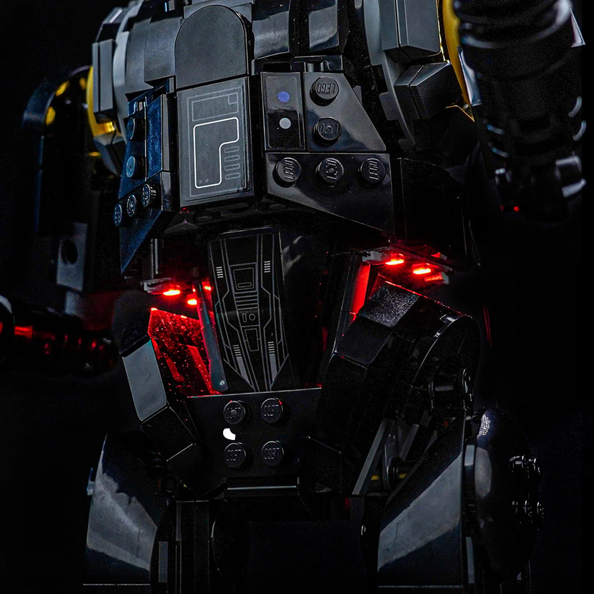 Nahaufnahme eines schwarzen Lego-Roboters mit roten Lichtern, die aus dem Brustbereich leuchten