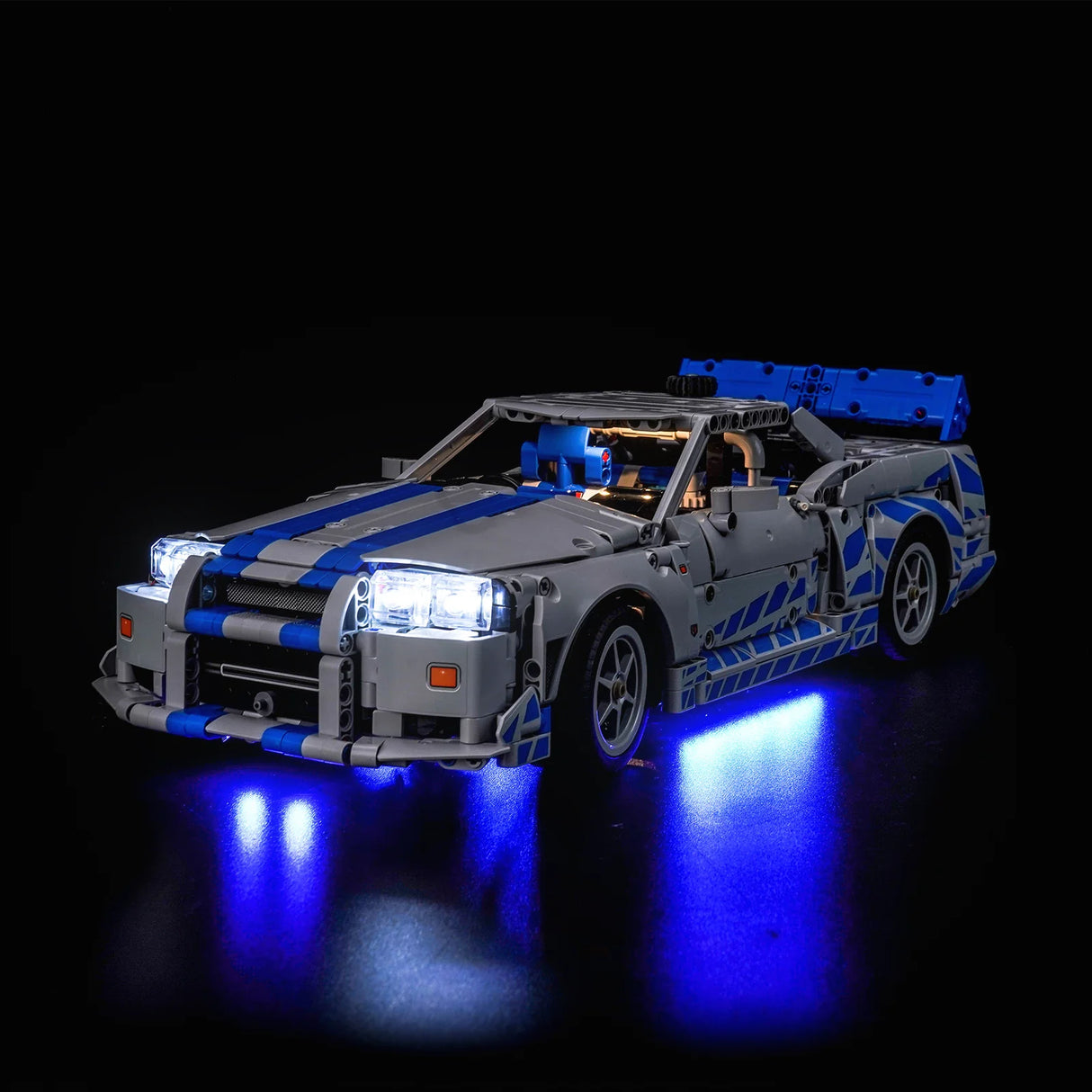 Graues Spielzeugauto mit blauen Streifen und leuchtenden Scheinwerfern und Unterbodenbeleuchtung