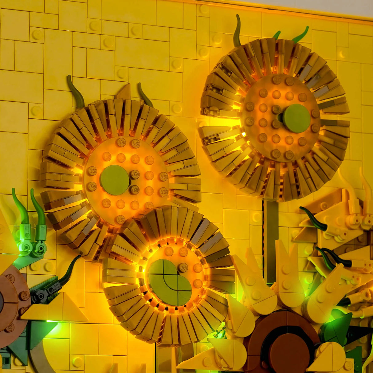 Drei leuchtende Lego-Sonnenblumen auf einer gelben Lego-Wand