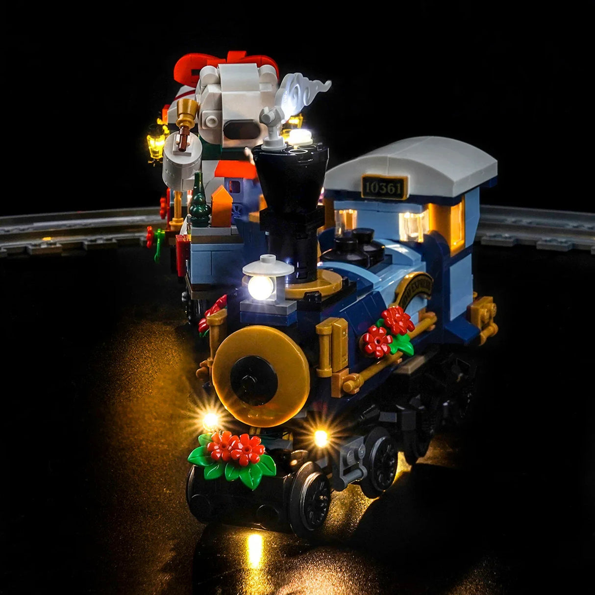 Beleuchteter blauer LEGO Zug mit roten Blumen und weißem Dampf auf schwarzem Hintergrund