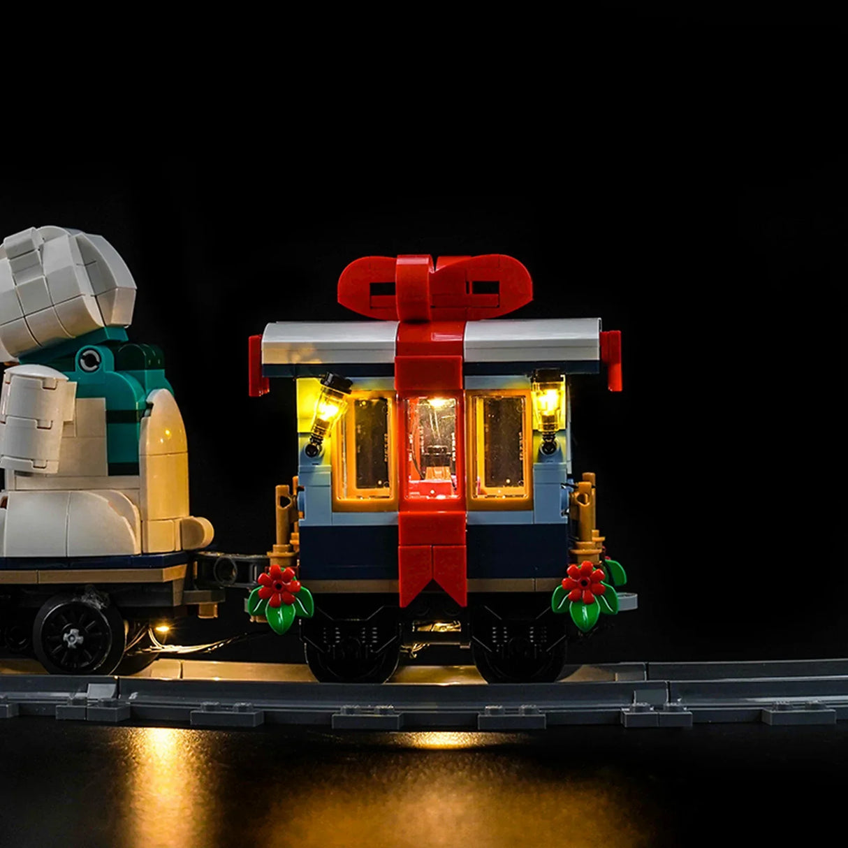 Beleuchteter LEGO Zug mit Geschenk-Waggon und Weihnachtsschmuck auf Schienen