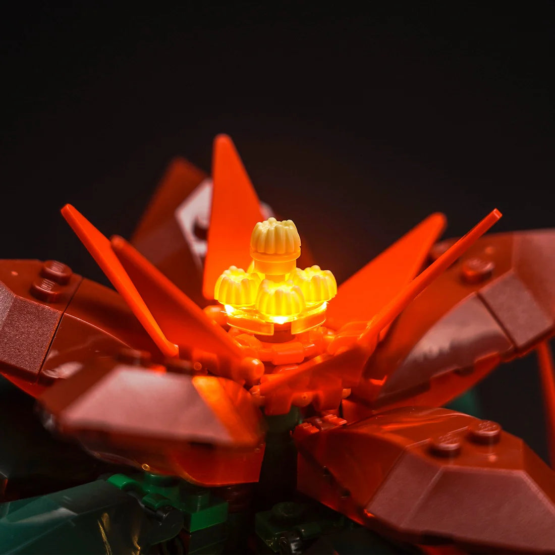 Nahaufnahme einer leuchtenden Lego-Pflanze mit roten Blütenblättern und einem gelb leuchtenden Zentrum