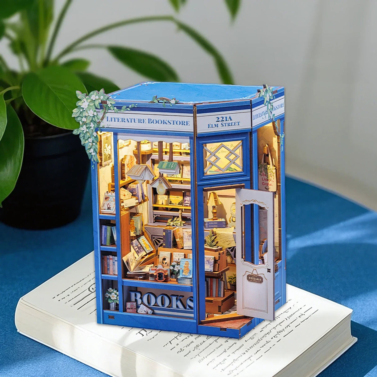Miniatur-Buchhandlung mit blauer Fassade, vielen Büchern und einer geöffneten Tür