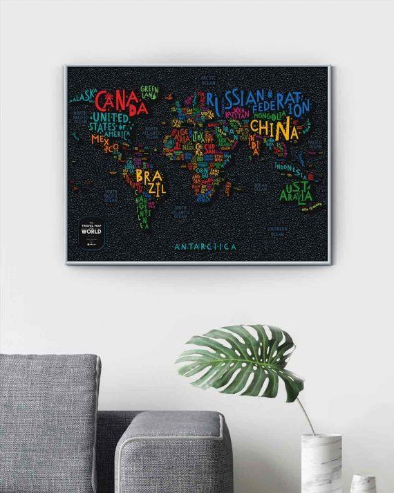 Weltkarte als Wandbild mit bunten Ländernamen auf schwarzem Hintergrund über einem Sofa