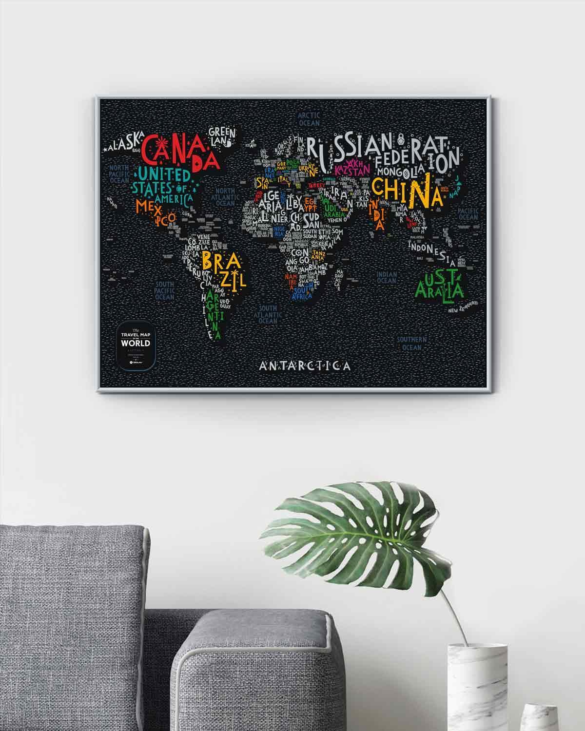 Wandbild mit einer typografischen Weltkarte auf schwarzem Hintergrund über einem grauen Sofa