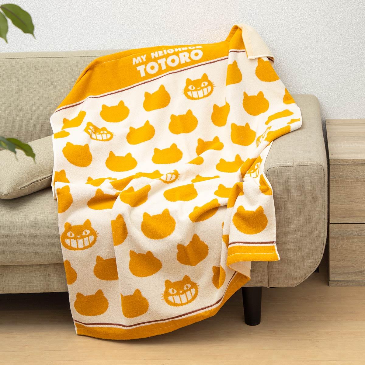 Gelbe und weiße Decke mit Totoro-Katzenmustern auf einem Sofa