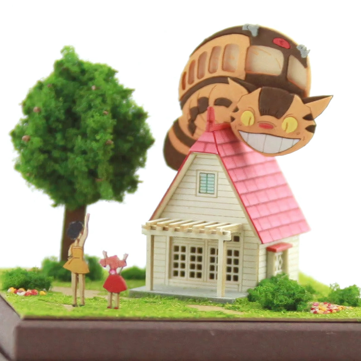 Modell eines Hauses mit rosa Dach, Baum, zwei Mädchen und Catbus-Figur auf dem Dach