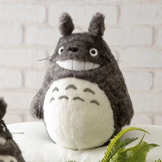 Graues Totoro-Plüschtier mit weißem Bauch und breitem Lächeln