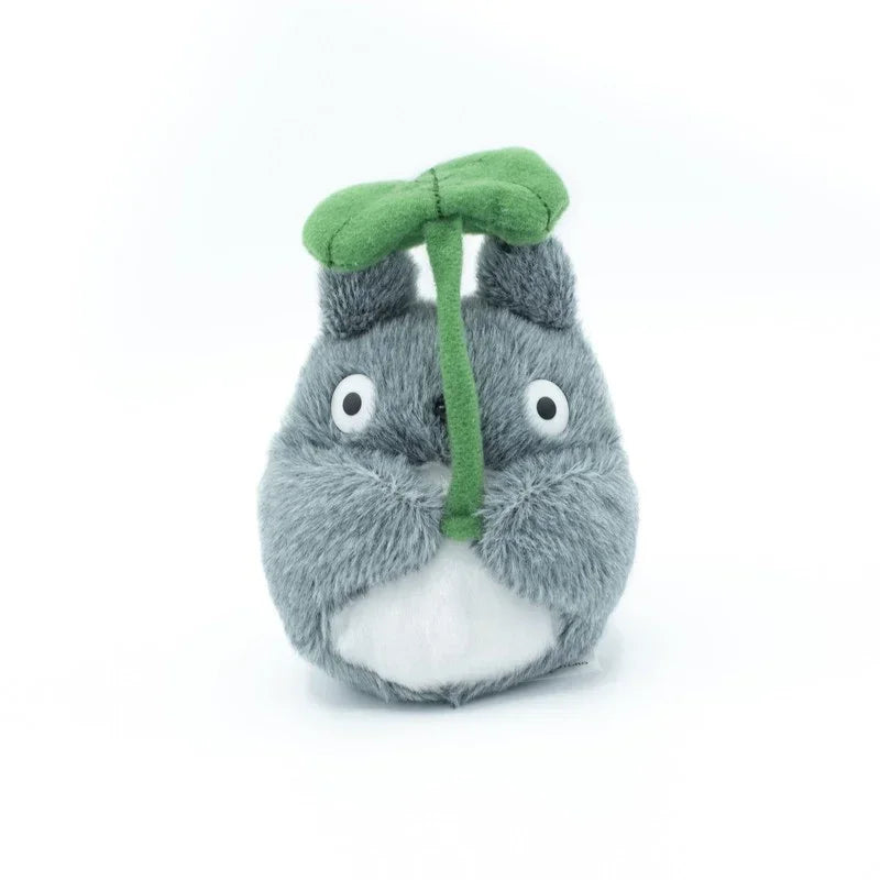 Graues Totoro Plüschtier mit grünem Blatt über dem Kopf