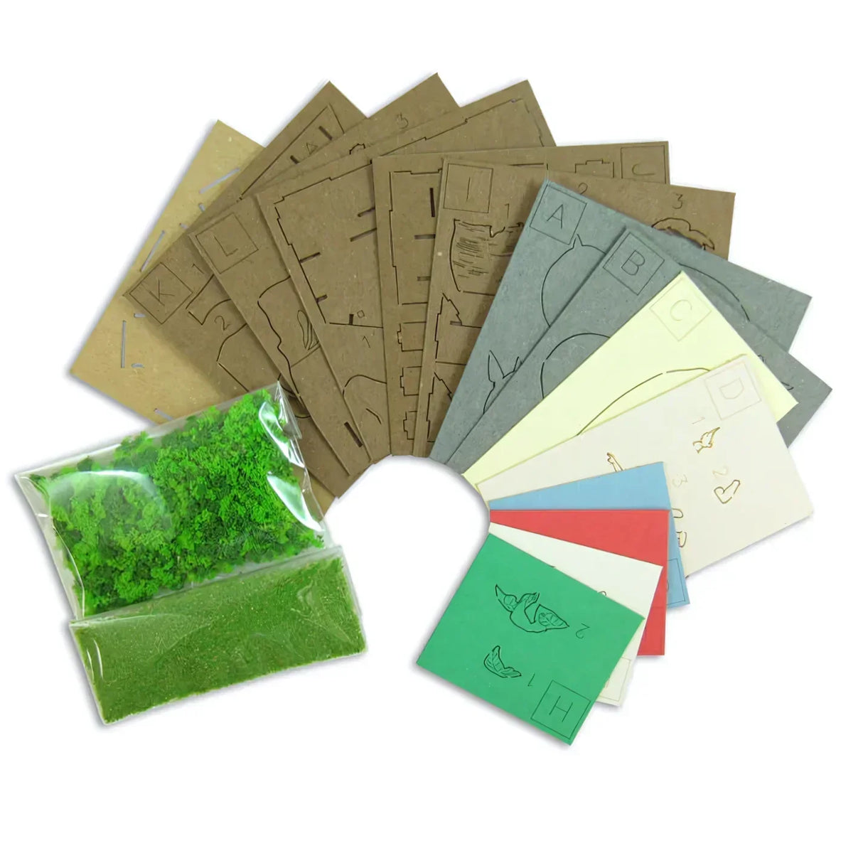 Bastelset mit braunen, grauen, gelben, roten, blauen und grünen Kartonbögen und zwei Beuteln mit grünem Streumaterial