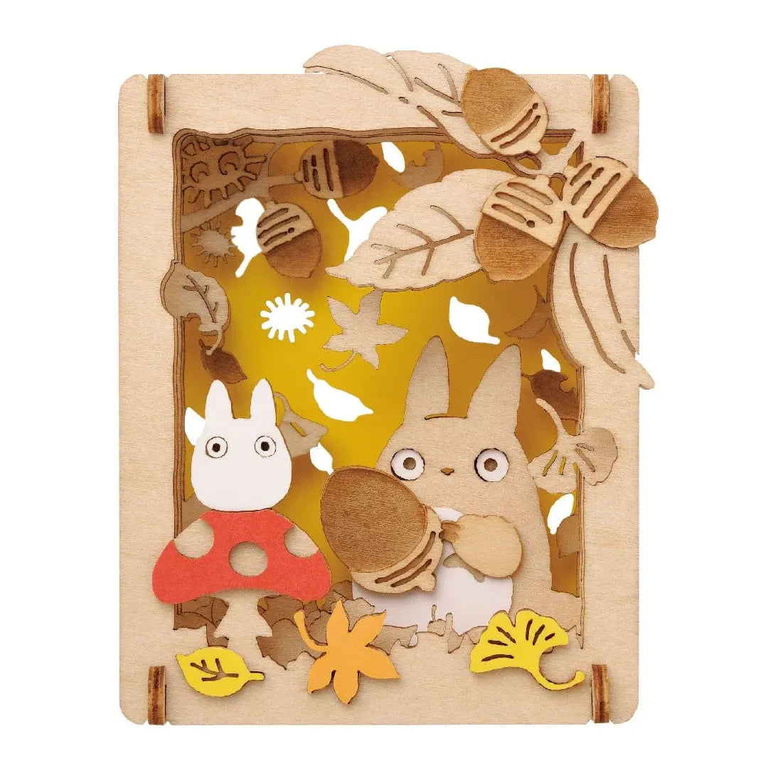 Totoro und Eicheln in einem Holzrahmen mit Herbstlaub